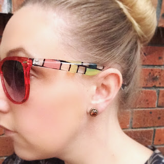 red sunglasses with check pattern arms