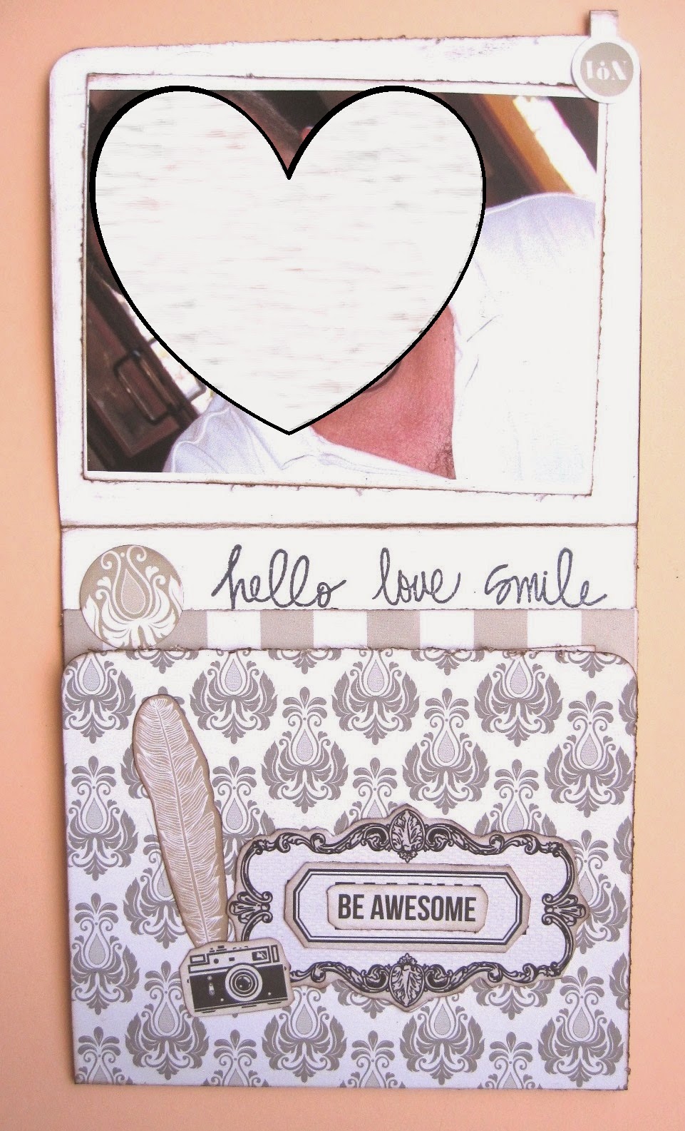 foto 8 decoración interior LOVE mini-álbum tarjeta tríptico vertical abierta en parte con pluma y cámara de ephemera y frase ‘be awsome’ y parte de decoración interior con sello ‘hello love smile’ y foto