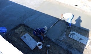 Smoothing out the next section of concrete Smoothing out the next section of concrete