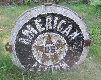 Black circle with white center and amber star inside, the word AMERICAN lettered around the upper arc