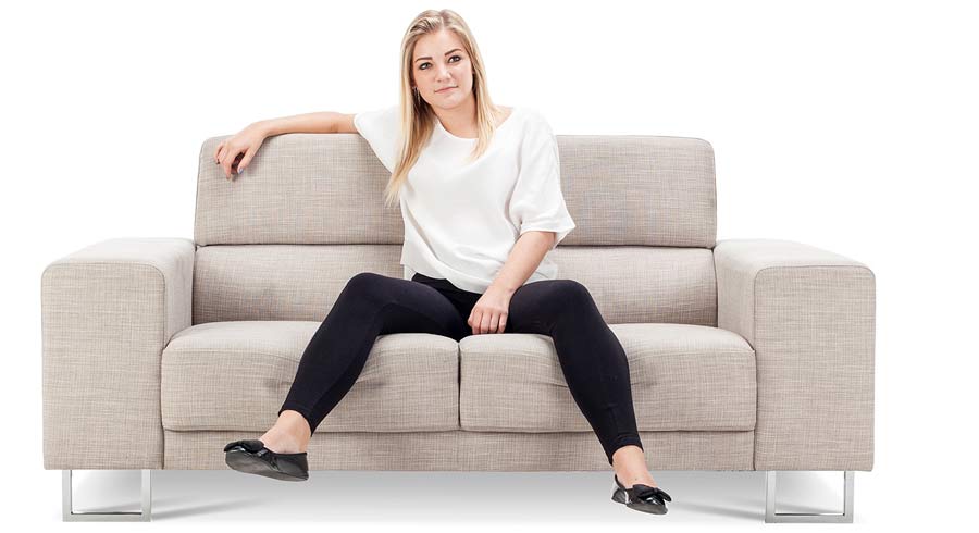 Блондинка в чулках сидит в офисе на диване фото