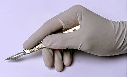 A Hand Holding a Surgery Knife Wearing a Surgical Glove