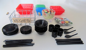 Selection of modern dolls' house miniature kitchen plasticware, and two salads: one in a bag, the other in a bowl.