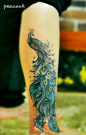 a gorgeous peacock tattoo on the leg with beautiful feather