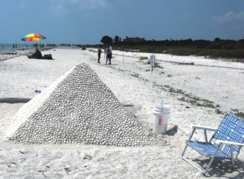 sand pyramid with shells on the beach