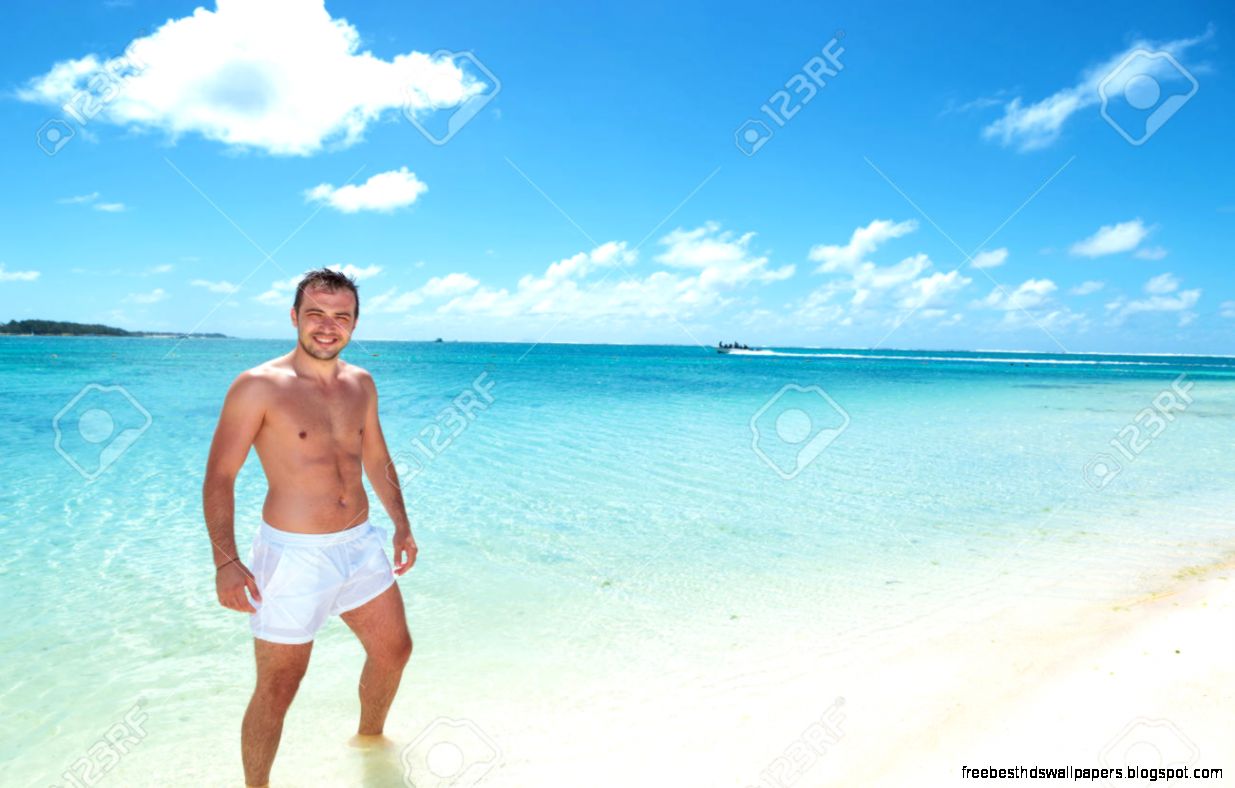 Man Standing On The Beach With Speed Boat In The Horizon In Man Standing On The Beach With Speed Boat In The Horizon In