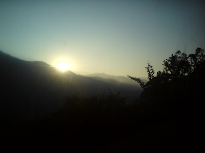 Sun peeping out from behind the clouds just before sunset  in the Garhwal Himalayas
