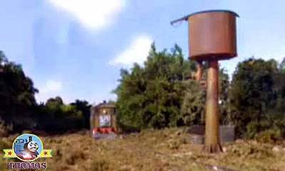 Tired Thomas and friends Toby the train engine stopped for a rest alongside a rusty old water tower