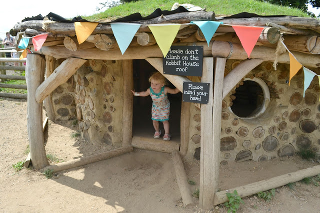Ti Box Tot looking out the door of a small stone and mud house