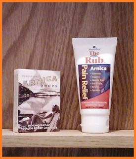 medicine cabinet shelf holes Arnica drops in a box and Arnica Rub (cream) in a squeezy tube.