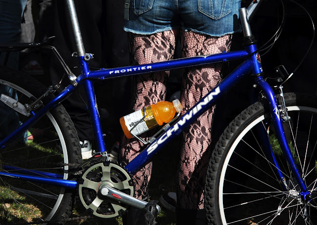 A girl wearing fishnet stockings with her Schwinn bike at the Denver 420 rally.
