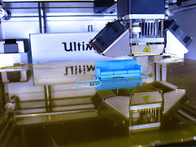 3D printer printing a miniature sofa.
