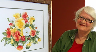 Rachel MacDonald at home with one of her favourite paintings. Note the prominence given to the white pansy.