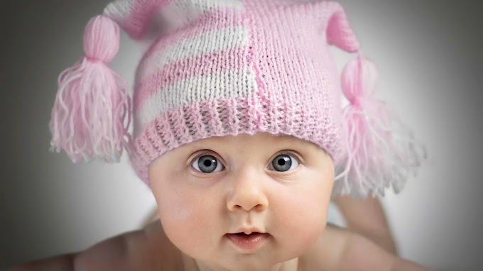 Foto van baby met roze muts