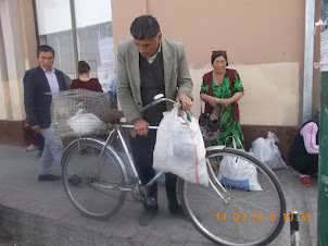 Local on a bicycle selling rabbits in Siyob Bazaar.