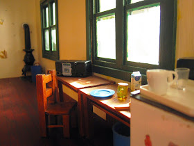 Miniature school house interior with breakfast set up on desks under a sunny window.