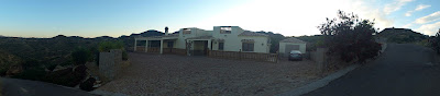 A panorama taking in the view of the front of the house at dusk.