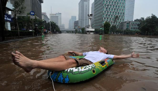 Gaya Tim Lehmann asal Jerman menikmati banjir di Jalan Thamrin Jakarta (Antara/ Fanny Octavianus)
