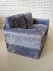Modern miniature two seater grey velvet sofa.