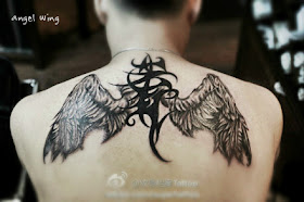 an angel wing tattoo with totem in between