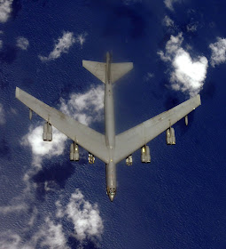  B-52 Stratofortress over sea top view with bombs.