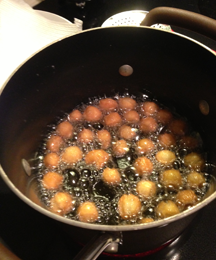 Image of struffoli frying in oil at 350 degrees.