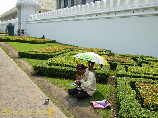 Musician-beaggar outside the walls of Grand Palace, Bangkok