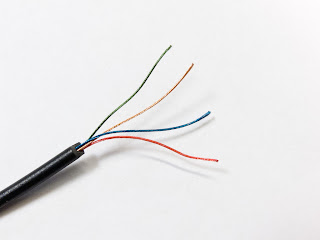 Cable cortado donde se puede ver que está formado por otros cuatro cables de colores