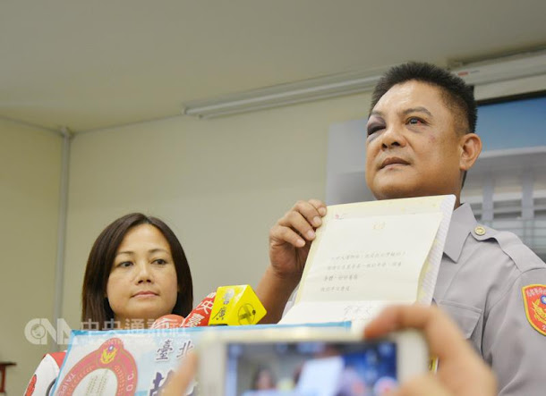 反年改民眾19日晚間在世大運開幕式時抗議,導致員警 劉金銓(右)受傷,劉金銓20日在太太(左)陪同下出 席記者會,並出示總統蔡英文的慰問狀。 反年改民眾19日晚間在世大運開幕式時抗議,導致員警 劉金銓(右)受傷,劉金銓20日在太太(左)陪同下出 席記者會,並出示總統蔡英文的慰問狀。