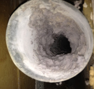 lint clogged this metal dryer vent duct in the wall reducing 4" duct to 1" opening