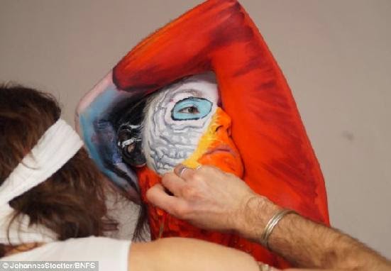Artist paints woman&#39;s entire body to make her look like a parrot
