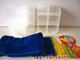 Two opaque plastic storage containers and a blue neck scarf from Daiso.