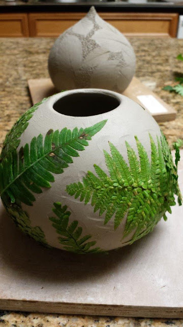 Ceramic pottery vessel with leaf imprints, this time fern fronds, in progress.