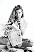 Amber Heard sitting on the floor reading the paper