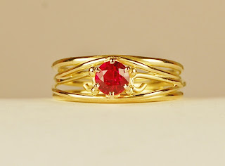 18k wirey yellow gold ring with round ruby. 
