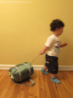 a child walking with a green bag