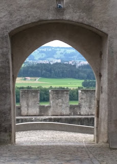 View of the valley through an opening in the wall of the old town, Gruyères, Switzerland