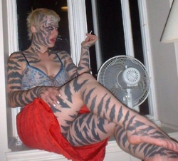 tatuaje de una mujer con rayas de tigre en todo el cuerpo incluida la cara