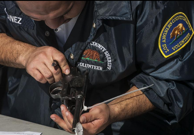 Gifts for Guns A Los Angeles County Sheriff's deputy checks a reclaimed pistol during a "Gifts For Guns" exchange program