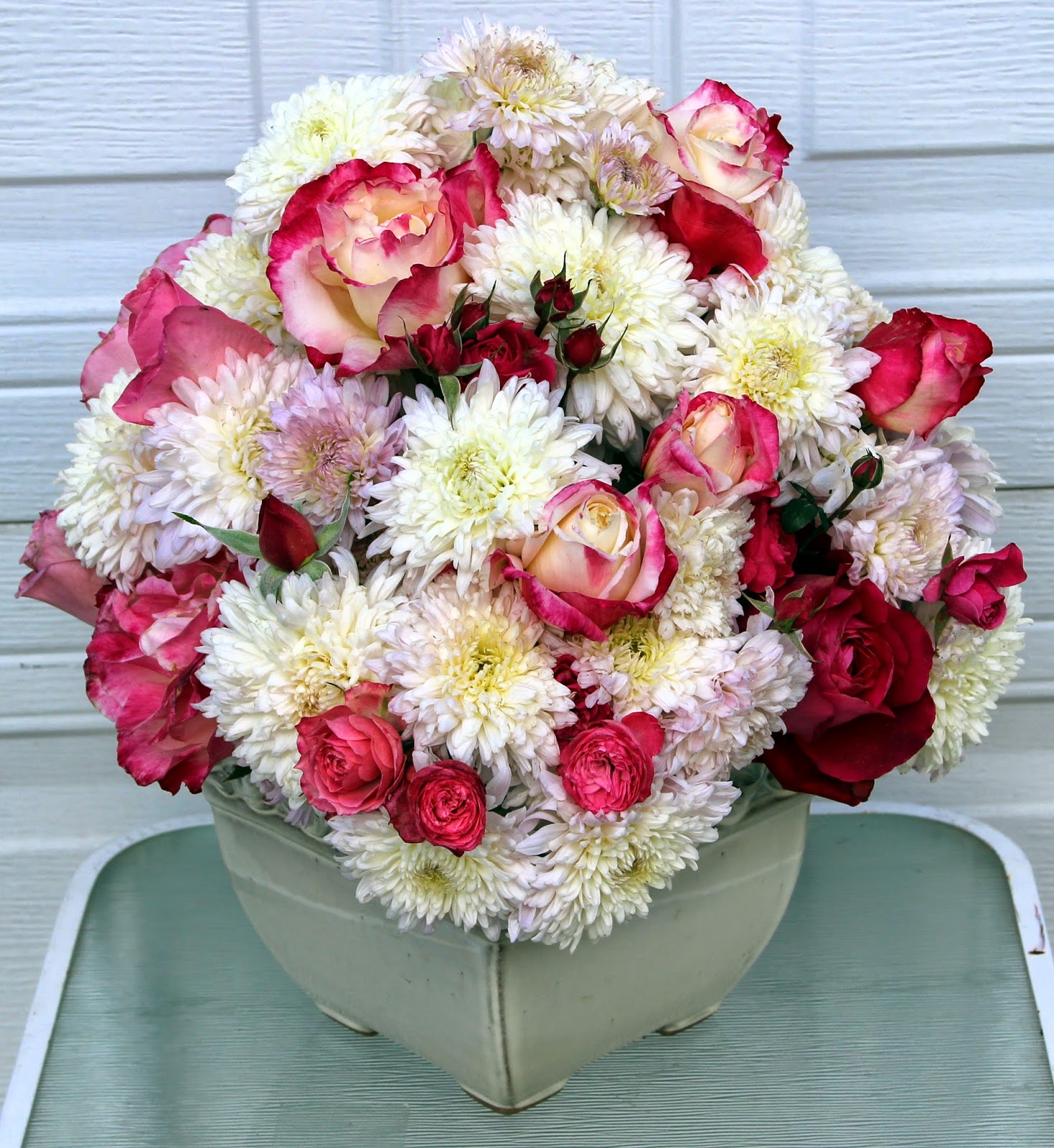 ROSES AND MUMS The last of the hybrid roses in a fall arrangement