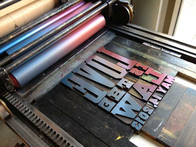 Bed of a metal letterpress with type set up that reads Love is the Law