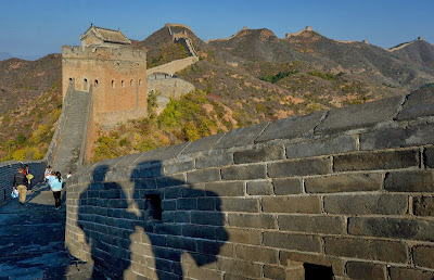 Visitors walk along the Badaling section of the Great Wall of China, some 70 kilometres north of Beijing on April 11, 2012. The Great Wall of China is a series of fortifications made of stone, brick, tamped earth, wood, and other materials generally built along an east-to-west line across the historical northern borders of China in part to protect the Chinese Empire against intrusions by various nomadic groups or military incursions.