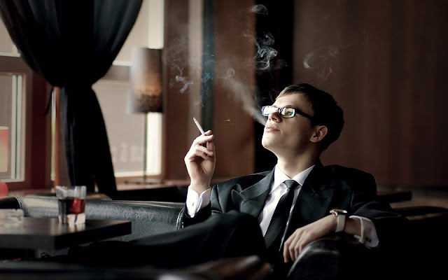 Young lawyer smokes cigarette and drinks whiskey