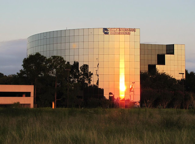 Gulf Interstate Engineering logo on top of its unique circle-shaped office building in West Houston at sunset
