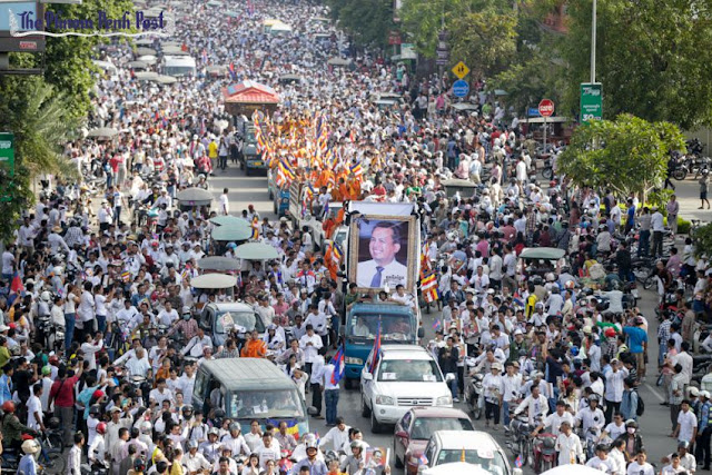 Thousands of people gather on Phnom Penh’s Monivong Boulevard yesterday morning to pay their respects to slain political analyst Kem Ley. Hong Menea