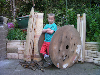 mr cool with army boots and cable drum for bonfire