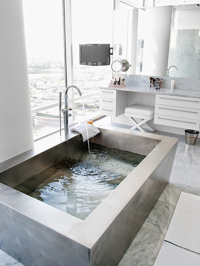 Metal freestanding tub in a white marble bathroom