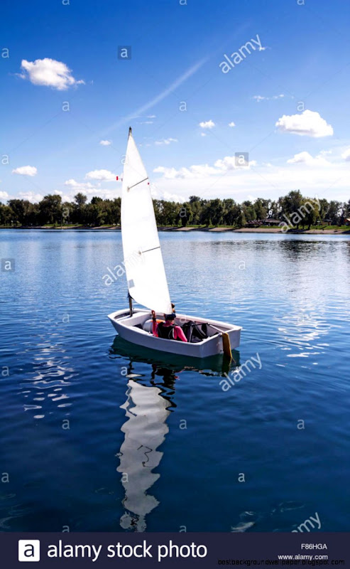 Small White Boat Sailing On The Lake On A Beautiful Sunny Day Small White Boat Sailing On The Lake On A Beautiful Sunny Day