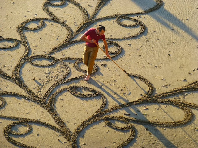 Artista utiliza un rastrillo para crear enormes pinturas de arena