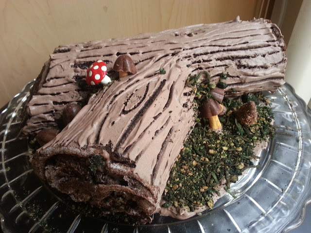Log cake (Buche de Noel) with bark frosting, candy mushrooms, and edible moss